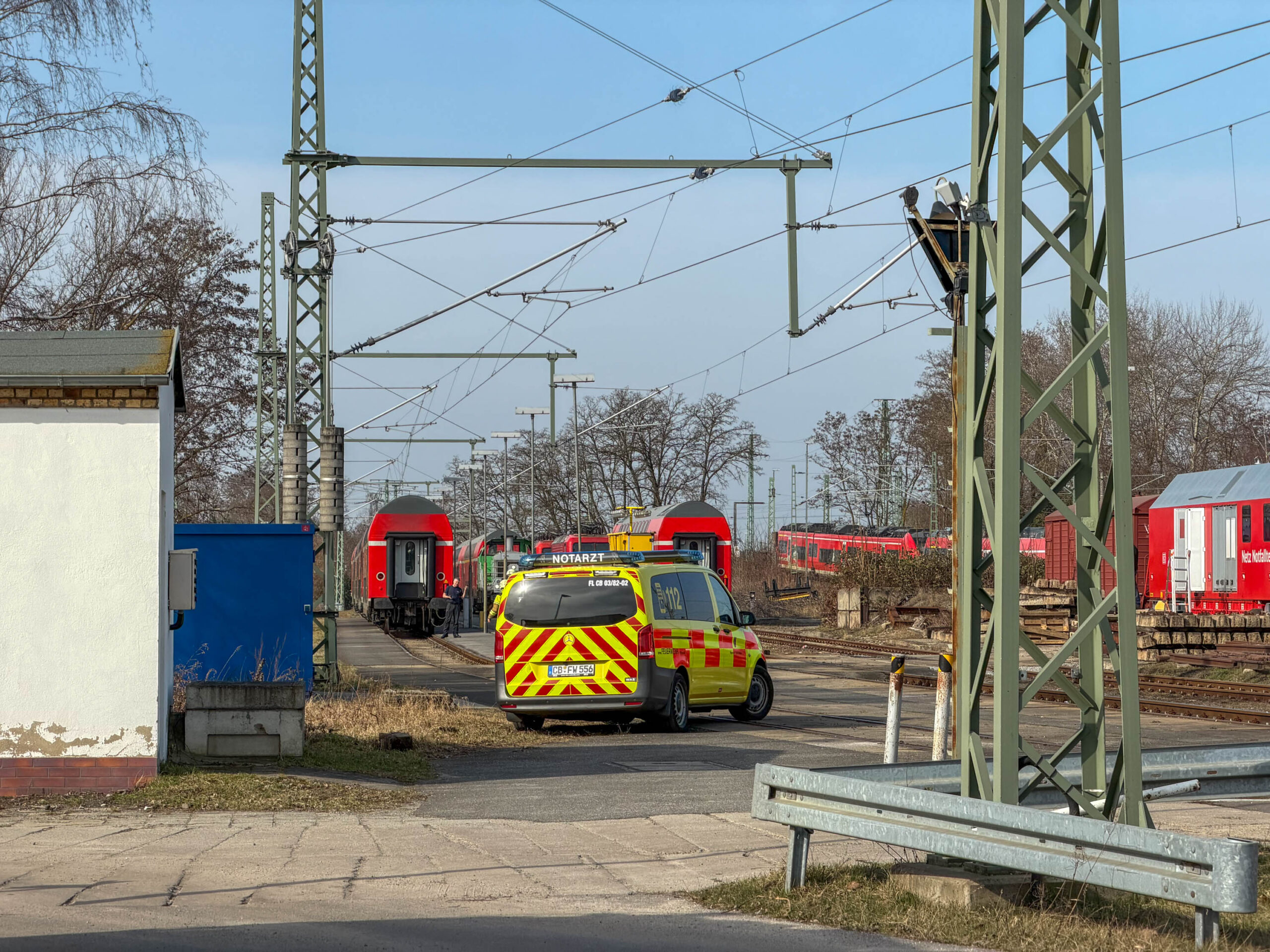 Bahngelände wo ein Zug und ein Notarztwagen stehen