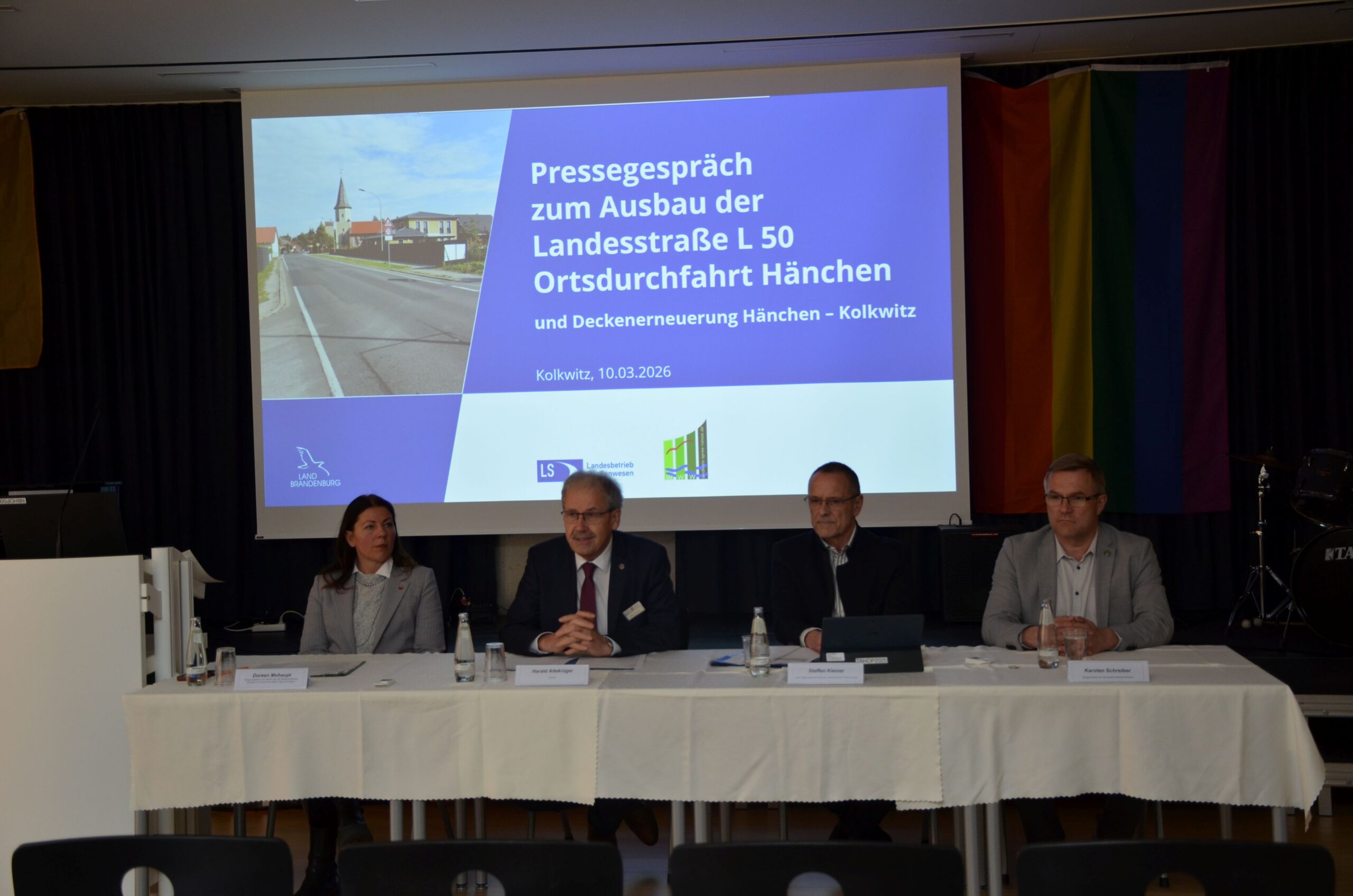 Vor eienr Tafel sitzen Politiker