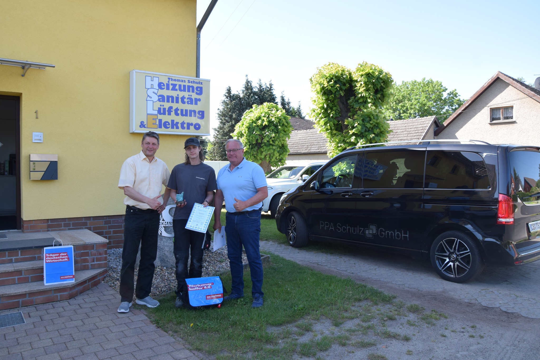 Gruppenfoto von einem Lehrling und seinem Ausbilder und Betreuer