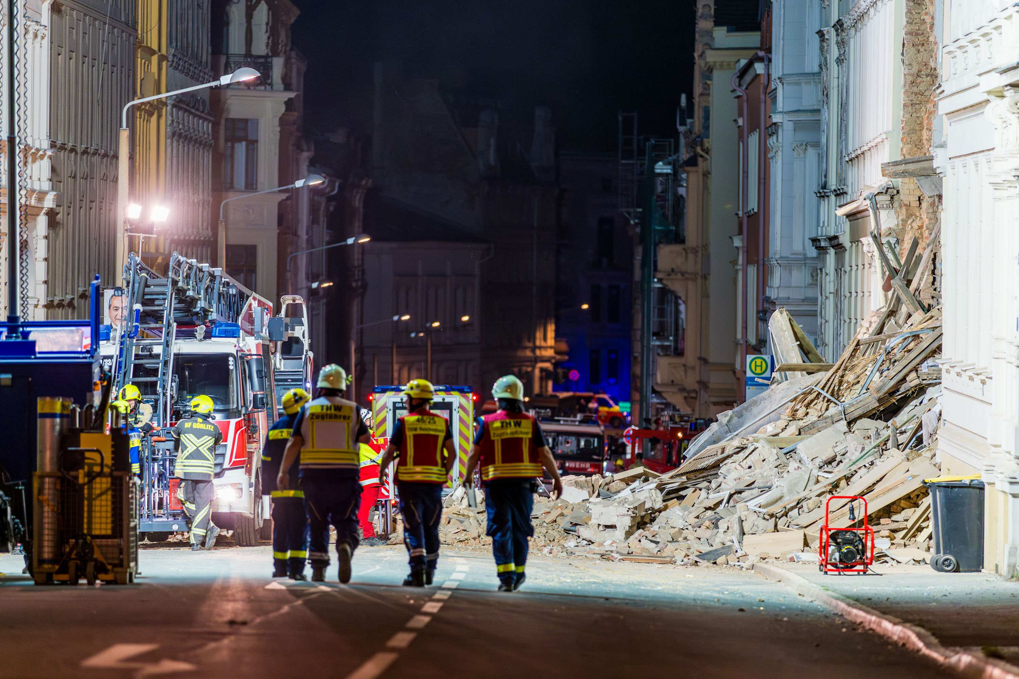 Einsatzkräfte stehen vor einem einsturzgefährdeten Haus