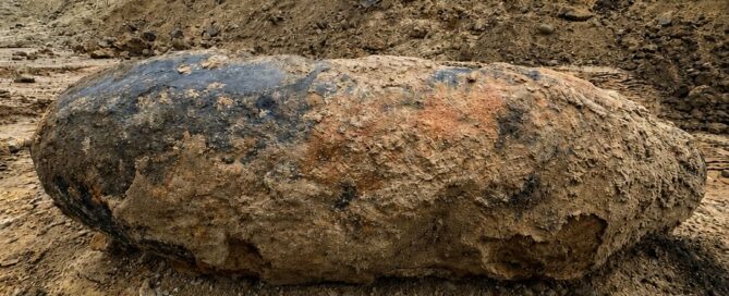 Bombe liegt in der Erde im Hintergrund steht ein Bagger