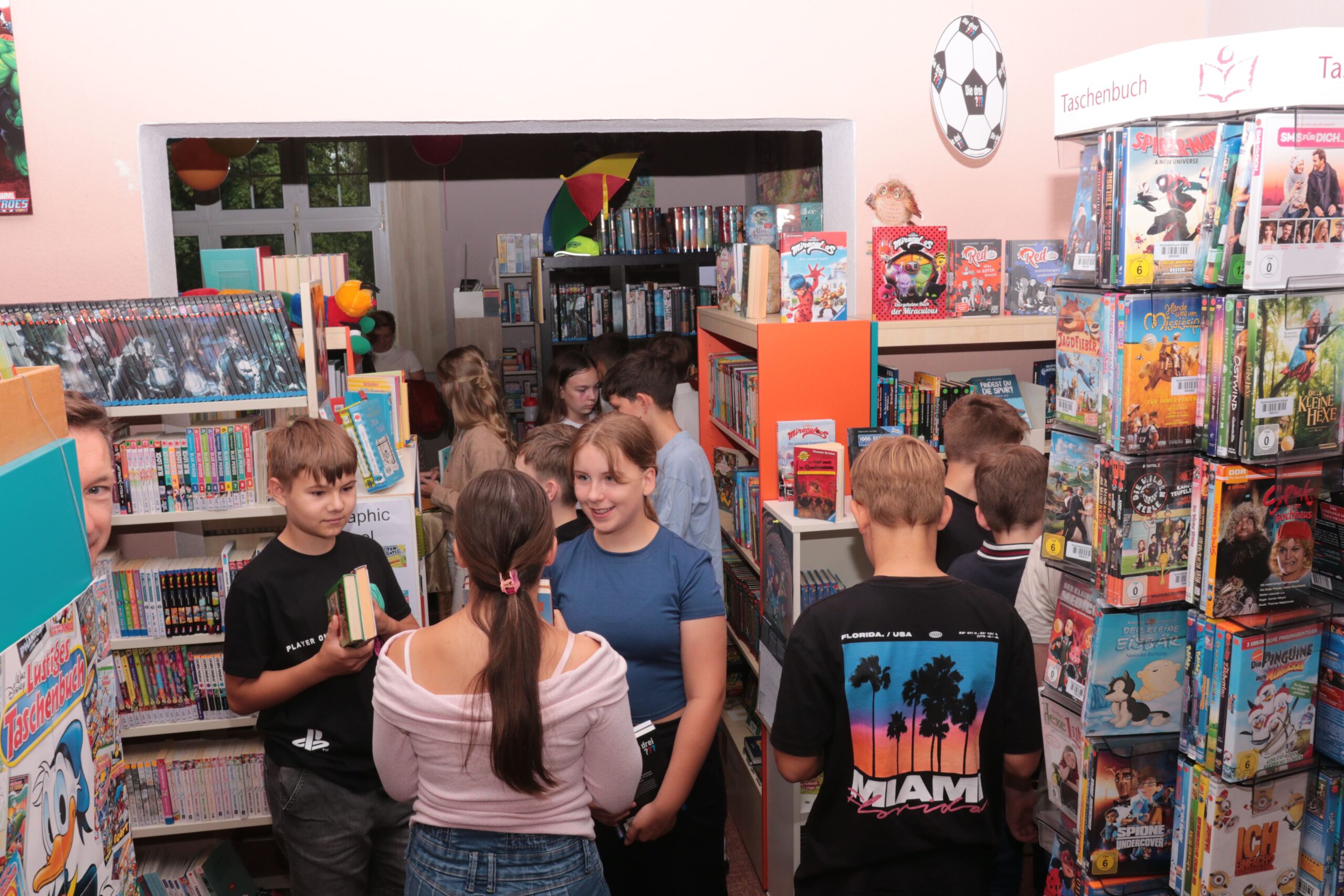 Leseseommer Kinder stehen am Bücherregal