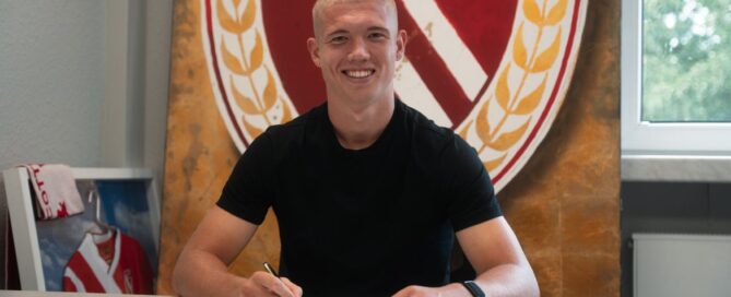 Ein Fussballspieler unterschreibt einen Vertrag
