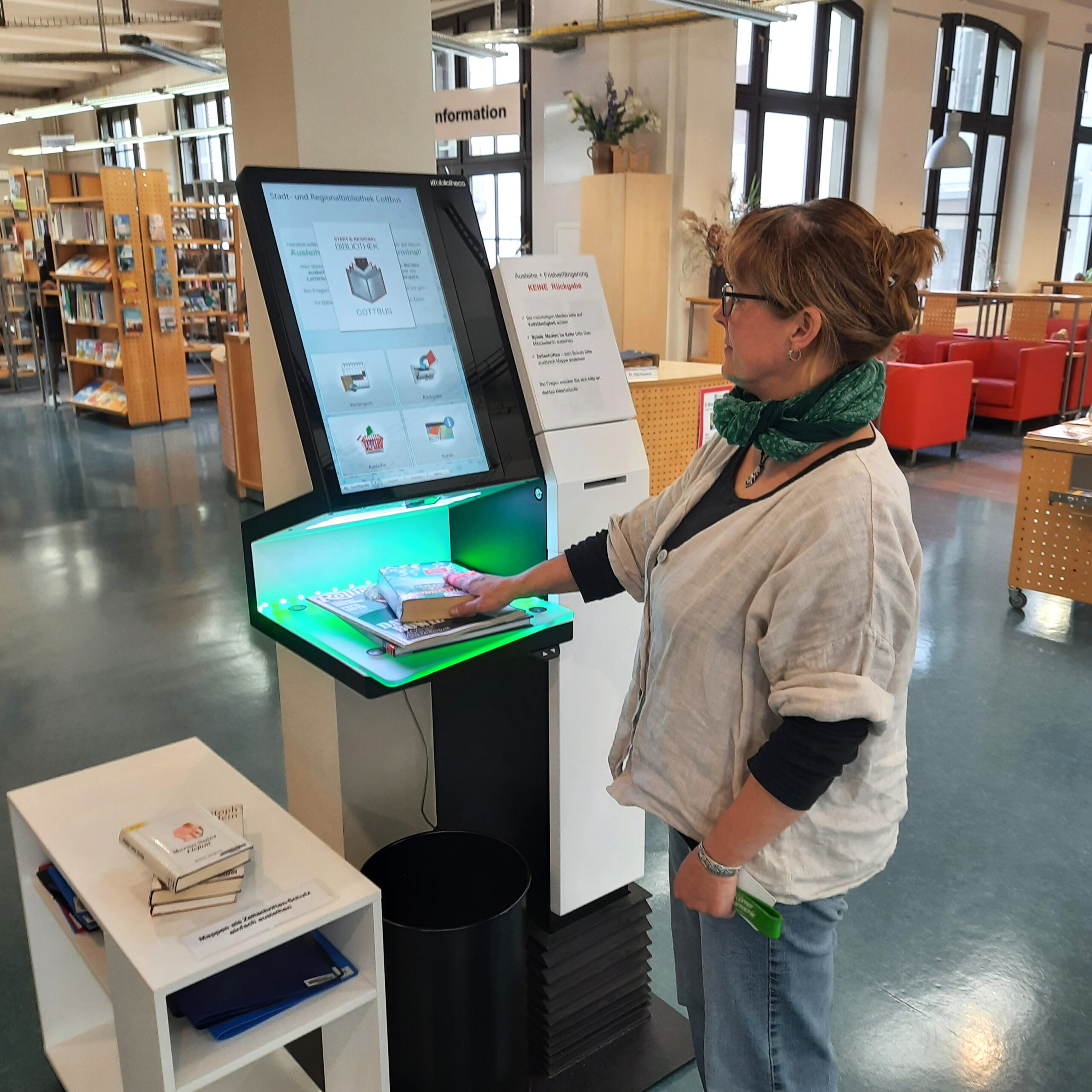 Bibliotheksmitarbeiterin Silke Glowka testet SB-Station c Uta Jacob Eine Frau steht an einem Serviceterminal