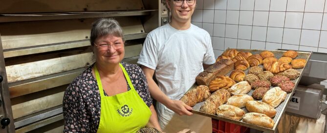 Ein Bäcker präsentiert Brötchen